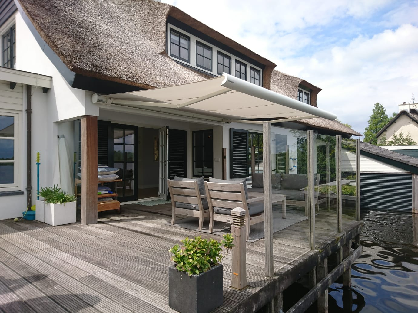 Knikarmscherm Opal Design aan rietgedekte villa.