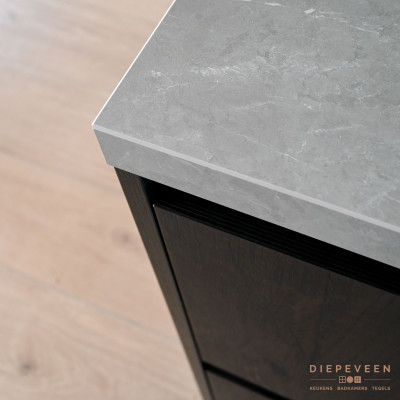 Het grijze werkblad is mooi in contrast met de donkere houtlook fronten