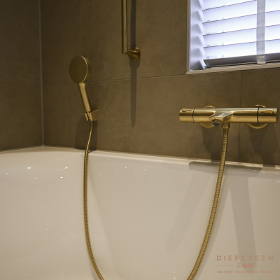 De kraan en douchekop zijn in goudlook