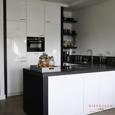 Witte keuken met een hoge kastenwand en een aaneengesloteneiland