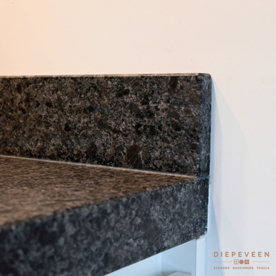 Donker granieten werkblad in combinatie met witte fronten