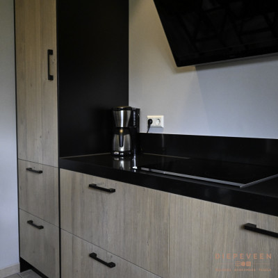 De eiken fronten zijn gecombineerd met een zwart composiet werkblad