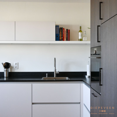 Het warme houtlook front staat in contrast met het witte front