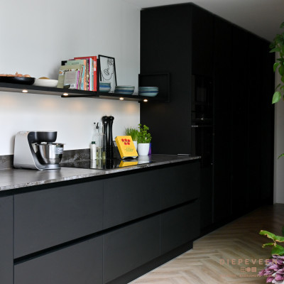 De kastenwand loopt door op het keukenblok