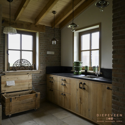 In de bijkeuken is gekozen voor dezelfde materialen en kleuren