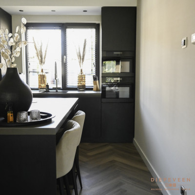 De keuken heeft een fijne doorloopruimte, De vloer kleurt prachtig bij de zwarte fronten