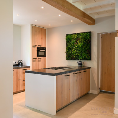 De open inkijk in de keuken geeft een ruimtelijk gevoel en laat de keuken totaal tot zijn recht komen