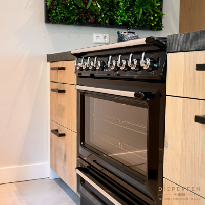 De keuken is voorzien van een stijlvol fornuis wat de landelijke stijl extra benadrukt