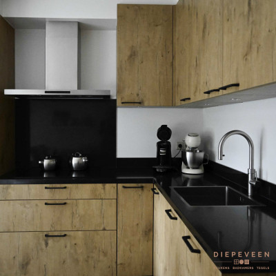 De keuken is in een hoek geplaatst zodat er meer kastruimte ontstaat