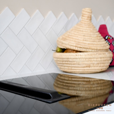 De witte tegels tegen de achterwand geven een speelse draai aan de keuken