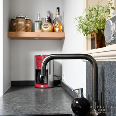 De donkere kraan matcht perfect met het werkbklad