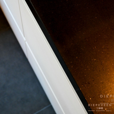 Het Aticca gepolijste werkblad is in contrast met de sneeuwwitte fronten