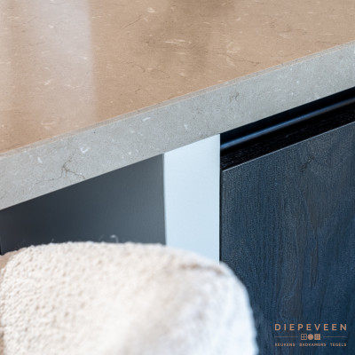 De crème barkrukken passen perfect bij het gepolijste zandkleurige werkblad