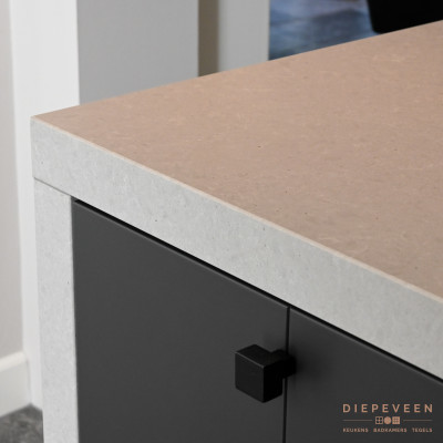 Omdat composiet gebruiksvriendelijker is ten opzichte van beton werd er gekozen voor het betonlook composieten werkblad van Dekker Zevenhuizen. Deze in combinatie met het MDF front met groef in structuurlak Carbon en de stijlvolle greep van Dauby creëren een prachtige match!