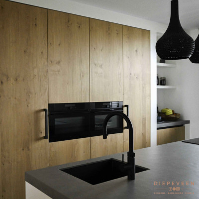 De eiken geborstelde fronten kleuren mooi bij het grijze werkblad