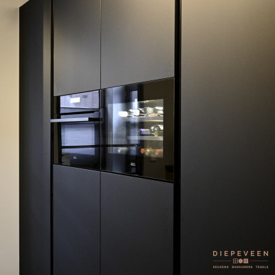 Kastenwand voorzien van inbouwwijnklimaatkast en een magnetron