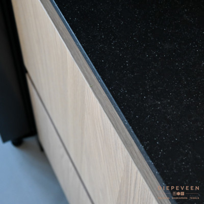 Licht houtlook fronten in combinatie met een zwart stijlvol werkblad