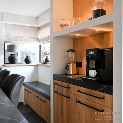 De nis maakt ruimte voor het koffieapparaat en wat gezellige accessoires. Ook kun je in deze keuken lekker zitten op het bankje in de hoek, deze past perfect bij de keuken en zorgt voor wat extra opbergruimte