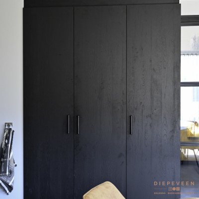 Zwart houtlook kastenwand met zwarte lange greep