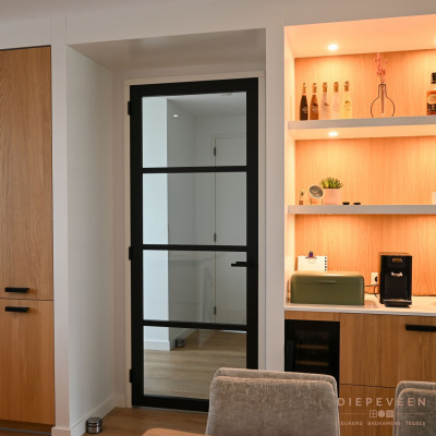 De zwarte greep combineert perfect met de stalen deur en de zwarte wijnkoeler. De nis maakt ruimte voor het koffiezetapparaat en gezellige accessoires. De verlichting zorgt voor een sfeervolle uitstraling