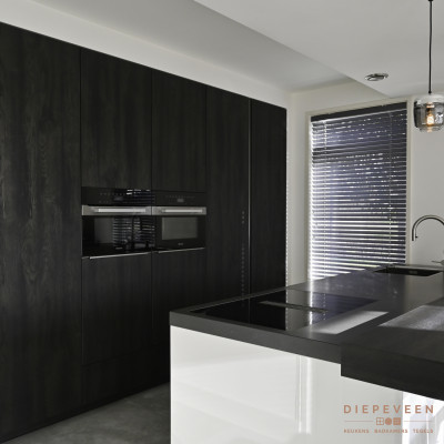 De donkerbruine kastenwand heeft genoeg opbergruimte en geeft tegelijkertijd een strak en mooie look