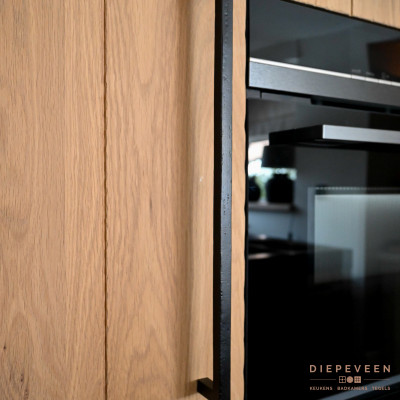 De zwarte robuuste grepen geven de keuken een landelijke uitstraling