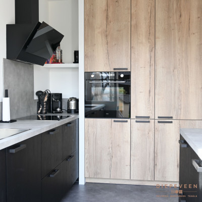 Zwarte fronten staan perfect in contrast met de grijze vloer en de houtlook kastenwand