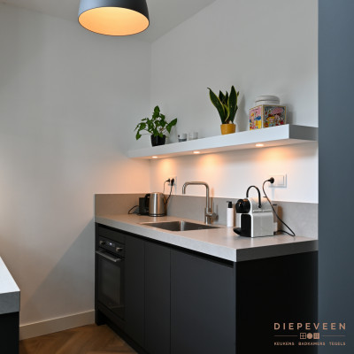 Om de ruimte optimaal te benutten is de keuken in twee delen verdeeld. Daardoor is de werkruimte goed verdeeld.