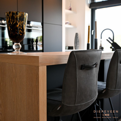 Aan het kookeiland is er plaats om te zitten. Of om s'avonds gezellig een drankje te doen.