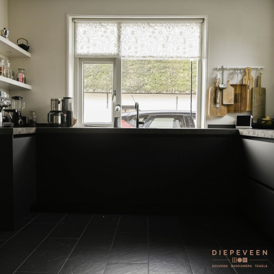 Zwarte tijdloze keuken met een keramiek werkblad