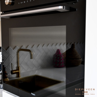 De zwarte oven is perfect in contrast met de witte fronten
