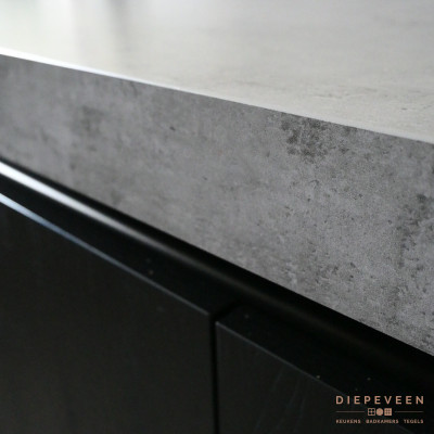 Zwarte greep loze fronten gecombineerd met een grijs werkblad.