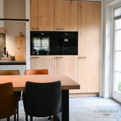 Houtlook kastenwand met een ingebouwd koffieapparaat en combi-stoomoven