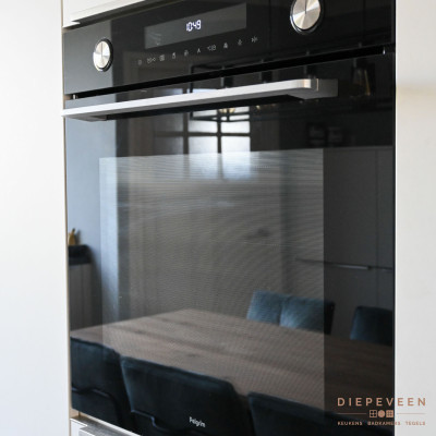 De keuken in voorzien van een zwarte stijlvolle oven met magnetron functie