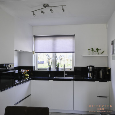 De hoekkeuken geeft door de gebruikte tinten een ruimtelijk gevoel