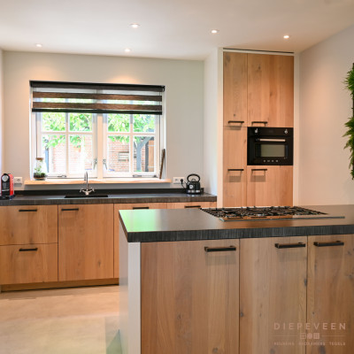 De keuken vormt één geheel met de houten deur