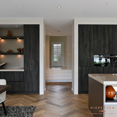 De keuken is voorzien van twee stijlvolle kastenwanden en een ruim eiland.