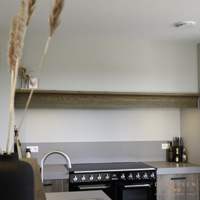 De houtlook plank en fronten geven de keuken een warme uitstraling