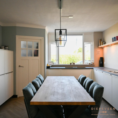 Aan de andere kant van de keuken is er een lage kastenwand geplaatst