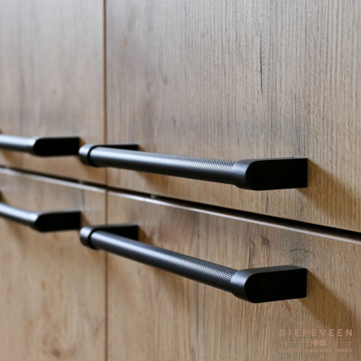 De zwarte strakke greep geeft de bijkeuken een moderne uitstraling