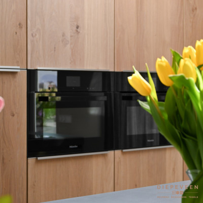 De keuken beschikt over de luxe van een multifunctionele oven met magnetronfunctie en een combi-stoomoven