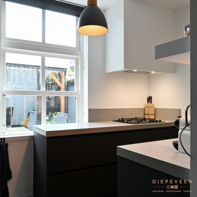 Tegenover de kraan vindt je de kookplaat. De stijlvolle schouw geeft de keuken een extra boost