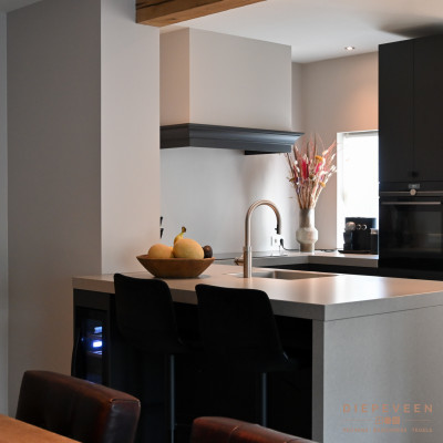 Landelijk moderne keuken voorzien van een schiereiland met een vrijstaande wijnklimaatkast.