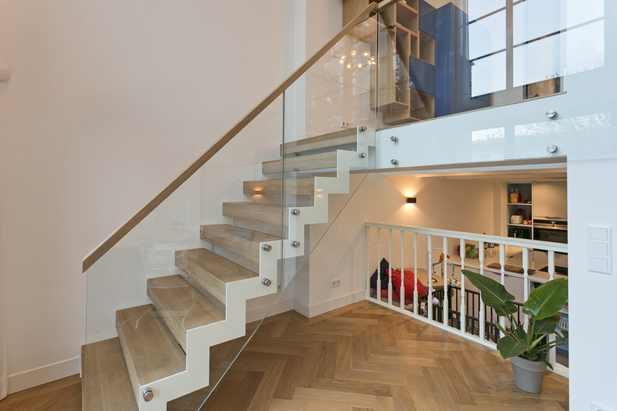 Stalen zigzag trap met balustrade van glas