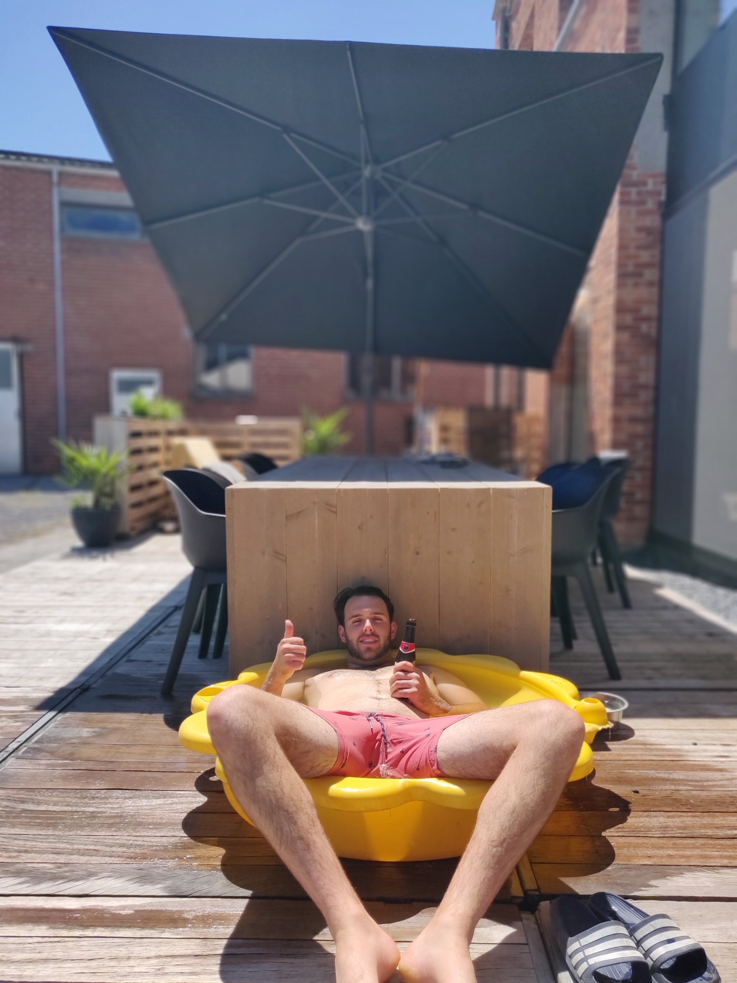 Deze strakke, moderne parasol komt zo goed van pas (toch voor diegene die aan tafel moeten zitten).
